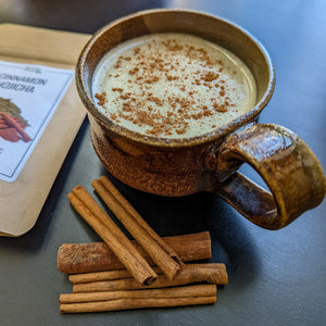 Mug filled with cinnamon hojicha latte sprinkled with cinnamon